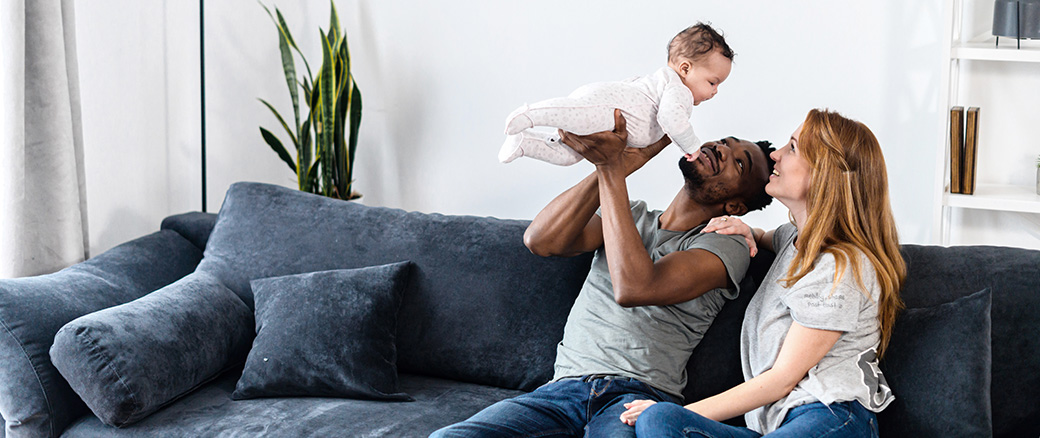 Parents sitting on the couch with their baby